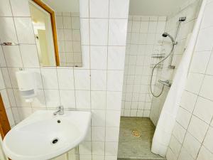 a white bathroom with a sink and a shower at aday - Randers Elegant and Trendy Apartment in Randers