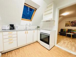 a kitchen with white cabinets and a stove at aday - Randers Elegant and Trendy Apartment in Randers