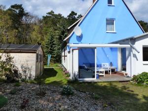 a blue and white house with a bench on a deck at Sandburg in Zempin