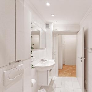 a white bathroom with a sink and a mirror at HG 03 Strandkorb in Tating