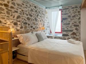 a bedroom with a white bed and a window at Archipelagos by halu! in Skiathos