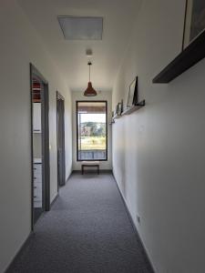 um corredor vazio com um banco e uma janela em Farmstay in Central Victoria em Ballan