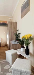 a living room with a table with flowers on it at Karancs Apartman Salgótarján in Salgótarján