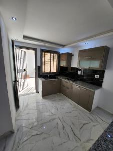 eine große Küche mit Marmorboden und einer Tür in der Unterkunft résidence el yassamine in Bizerte