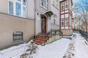 a house with snow in front of it at Downtown Apartments Sopot Chopina Seaside in Sopot