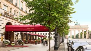 una strada con un tendone rosso su un edificio di Hotel Adlon Kempinski Berlin a Berlino