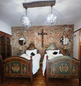 a bedroom with two beds and a brick wall at Naauwpoort View in Clarens