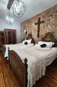 a bedroom with two beds and a cross on the wall at Naauwpoort View in Clarens