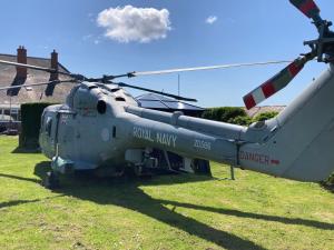 un hélicoptère garé sur l’herbe dans un champ dans l'établissement Haelarcher Helicopter Glamping, à Helston