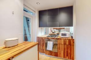 a kitchen with wooden counter top and a microwave at Modern 2 Bed Apartment near Acton Central Tube Station - Sleeps 4 in London