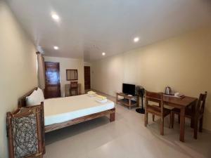 Amor Double Room with Swimming Pool في بوراكاي: غرفة نوم بسرير وطاولة ومكتب