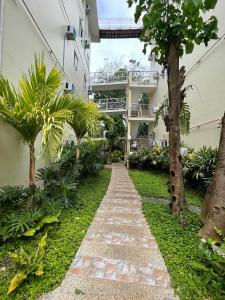 una pasarela frente a un edificio con árboles en Amor Double Room with Swimming Pool en Boracay