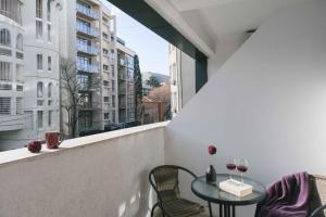 Round Garden Hotel في تبليسي: شرفة مع طاولة وكراسي ونافذة