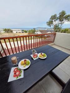 a picnic table with two plates of food on it at A Time And A Place in Plettenberg Bay