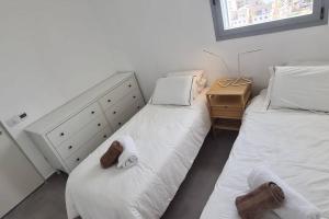 a bedroom with two beds and a dresser with towels at וגאס in Bayit Wegan