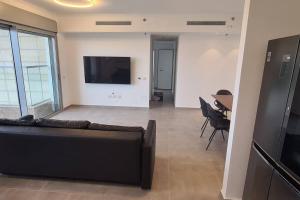 a living room with a couch and a tv and a table at וגאס in Bayit Wegan