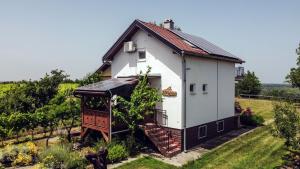 a small white house with a door in a field at Rural House Veranda in Šarengrad