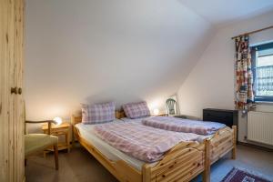 1 dormitorio con 1 cama, 1 silla y 1 ventana en Ferienwohnung Frechehof 136 qm, en Bad Peterstal-Griesbach