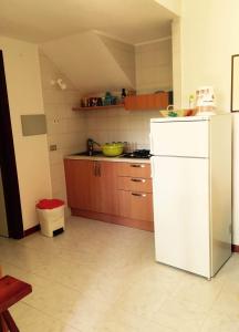 サンタ・マルゲリータ・ディ・プーラにあるAppartamento Renataのキッチン(白い冷蔵庫、木製キャビネット付)
