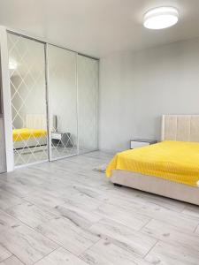 a bedroom with a yellow bed and a mirror at Truskavets Oasis Apartments in Truskavets