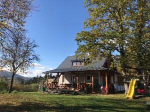 une maison avec un toit en gambrel et une aire de jeux dans l'établissement HolidayHome Sauna Kyselka, à Šemnice