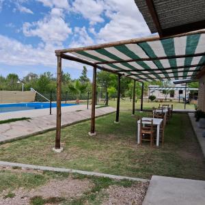 un patio con mesa y sillas bajo un dosel en CABAÑAS SOL Y LUNA en San Rafael