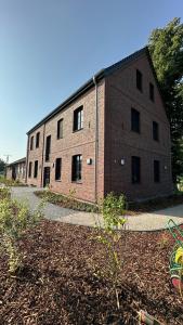 a large brick building with windows on the side of it at Ferienwohnungen Hamminkeln, Berg4Home in Hamminkeln