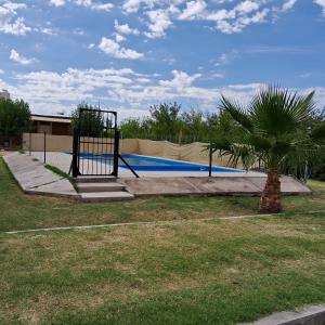 un aro de baloncesto en un parque con una palmera en CABAÑAS SOL Y LUNA en San Rafael