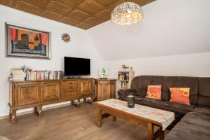 sala de estar con sofá y TV en Ferienwohnung Frechehof 136 qm, en Bad Peterstal-Griesbach