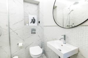 a white bathroom with a sink and a mirror at Apartament UKIEL PARK 39 przy Plaży Miejskiej - klimatyzacja,free parking,FV in Olsztyn +20 photos