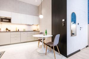 a kitchen with a white table and two chairs at Apartament UKIEL PARK 39 przy Plaży Miejskiej - klimatyzacja,free parking,FV in Olsztyn