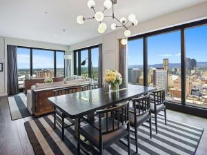 a dining room with a table and chairs and a couch at Sofitel Adelaide in Adelaide