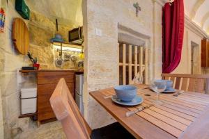 a kitchen with a wooden table in a room at Quaint TownHouse in Cospicua in Cospicua +12 photos