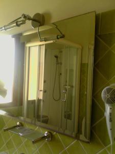 a mirror in a bathroom with a shower at Hotel I Colori in SantʼAntìoco