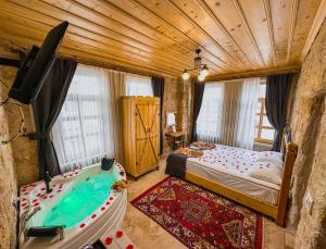 a bedroom with a tub and a bed in a room at Tantan Cappadocia House in Avcılar