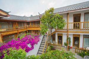 Lijiang Flowers Valley Inn في ليجيانغ: منظر خارجي لبيت به زهور