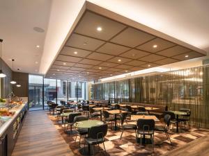 un restaurante con mesas y sillas en un edificio en Mercure Melbourne Southbank en Melbourne