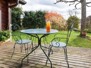 a table with an orange juice sitting on a patio at Spacious Chalet in Abbevillers with Swimming Pool in Abbévillers