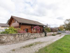 a house with a stone wall next to a road at Spacious Chalet in Abbevillers with Swimming Pool in Abbévillers