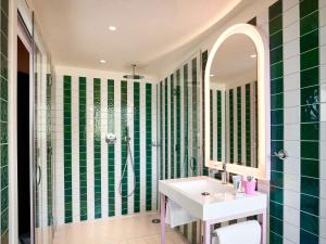 a green and white bathroom with a sink and a shower at Mama Shelter Dijon in Dijon