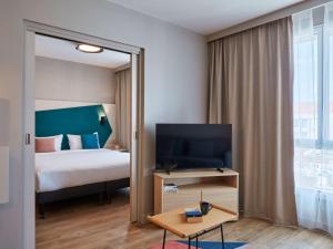 ein Hotelzimmer mit einem Bett und einem großen Fenster in der Unterkunft Aparthotel Adagio Original Toulouse Centre La Grave in Toulouse
