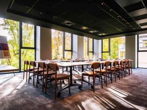 a long table and chairs in a room with windows at TRIBE Lyon Croix Rousse in Lyon