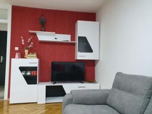 a living room with a television and a white entertainment center at Apartment Centar with garage in Velika Kladuša