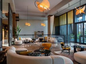 a living room with couches and chairs and windows at Banyan Tree Dubai at Bluewaters in Dubai