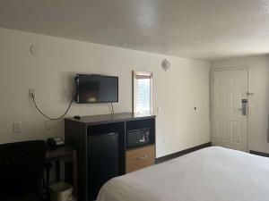 1 dormitorio con 1 cama y TV en la pared en Motel 6 Cross Lanes, WV Goff Mountain Rd, en Cross Lanes