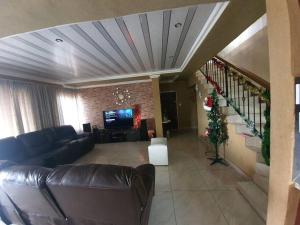 a living room with a couch and a christmas tree at Dumi Place in Mataffin