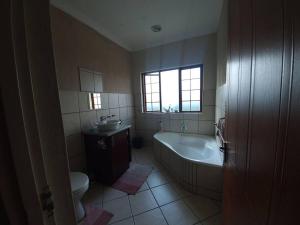 a bathroom with a tub and a sink and a toilet at Dumi Place in Mataffin