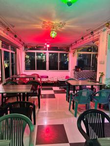 a restaurant with tables and chairs and red lighting at Nukkad Guest House in Udaipur