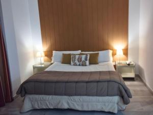 1 dormitorio con 1 cama grande y 2 mesitas de noche en Hospedium Hotel Apartamentos Simón Verde en Mairena del Aljarafe