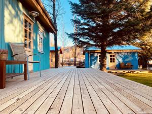 una terraza de madera frente a una casa con un árbol en Backyard Village, en Hveragerði